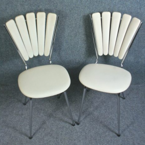A pair of vintage scallop back white vinyl and chrome chairs