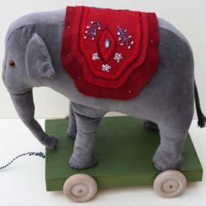 A traditional pull along velvet elephant