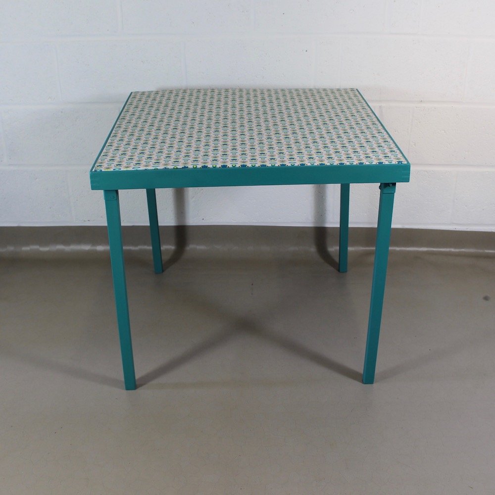 An up-cycled turquoise folding occasional table covered in Scandi style oilcloth