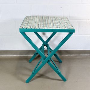 An up-cycled turquoise folding occasional table covered in Scandi style oilcloth