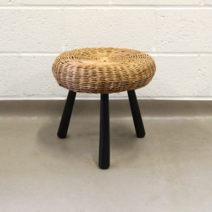 A 1950's Tony Paul tripod wicker stool with black legs.