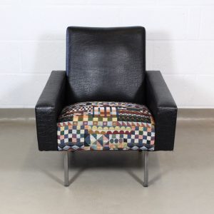 A 1960's black vinyl leather arm chair upholstered with Bauhaus fabric .