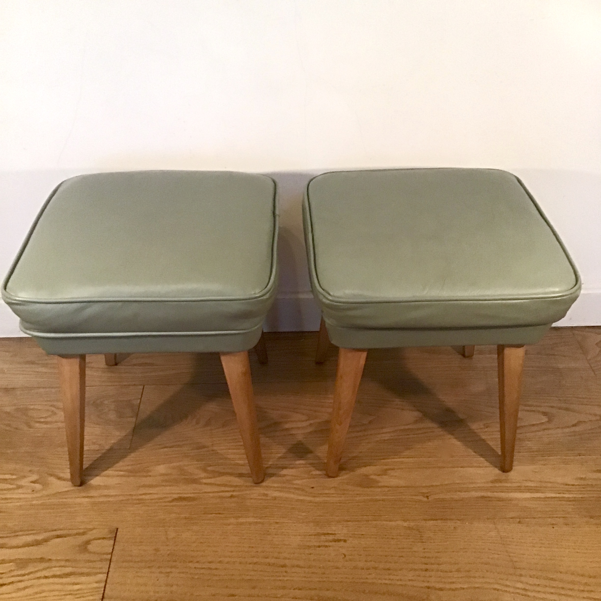 A 1950's pair of vintage green leather stools