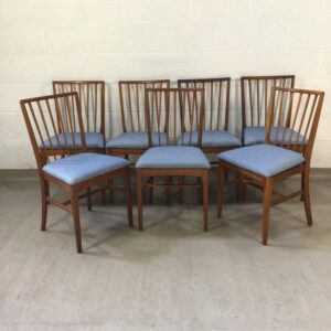 A set of 7 Mid-century tapering spindle back teak chairs re-uphostered in blue herring bone fabric