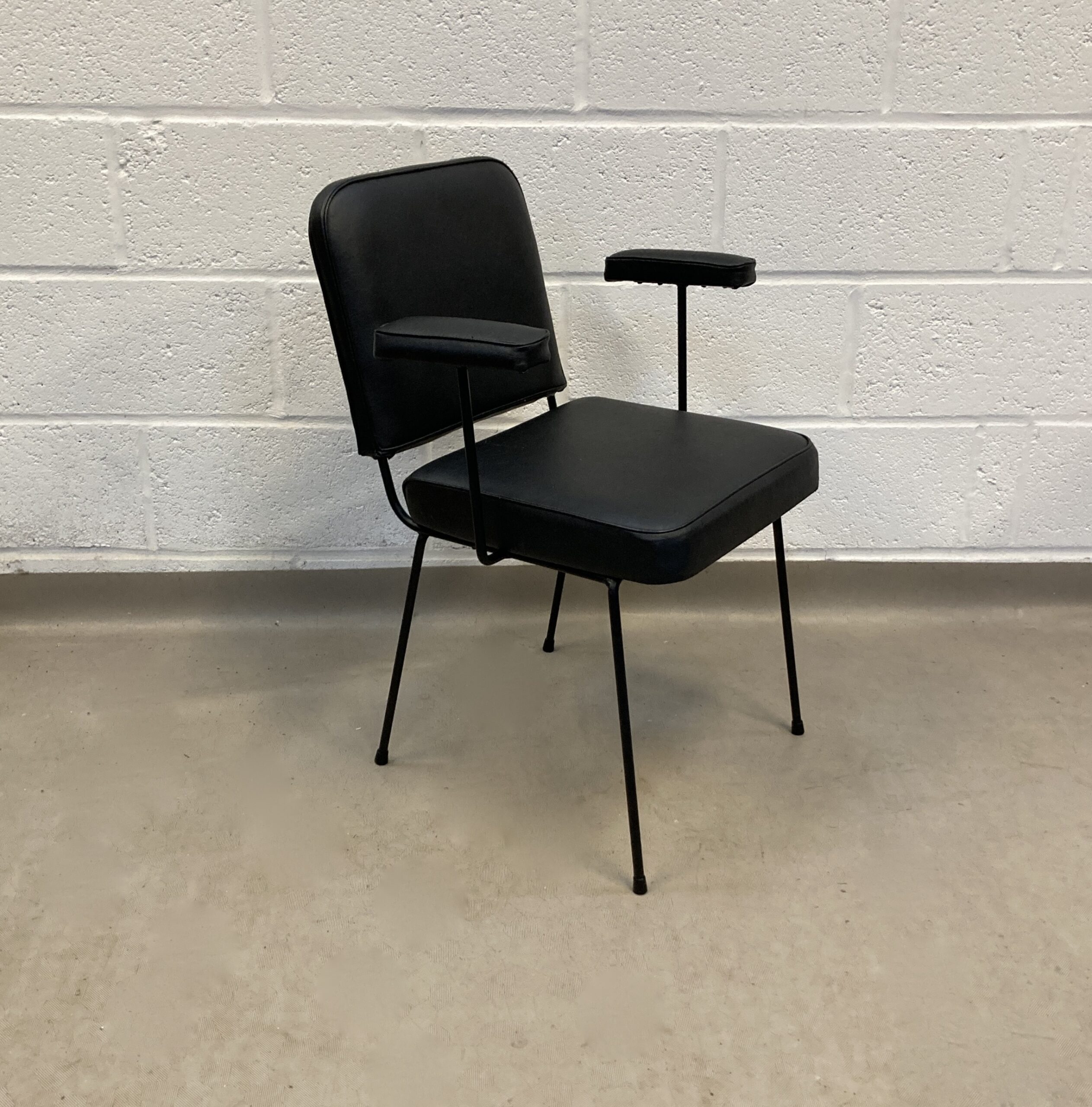 A French Wire framed black vinyl office chair in the style of Pier Paulin.